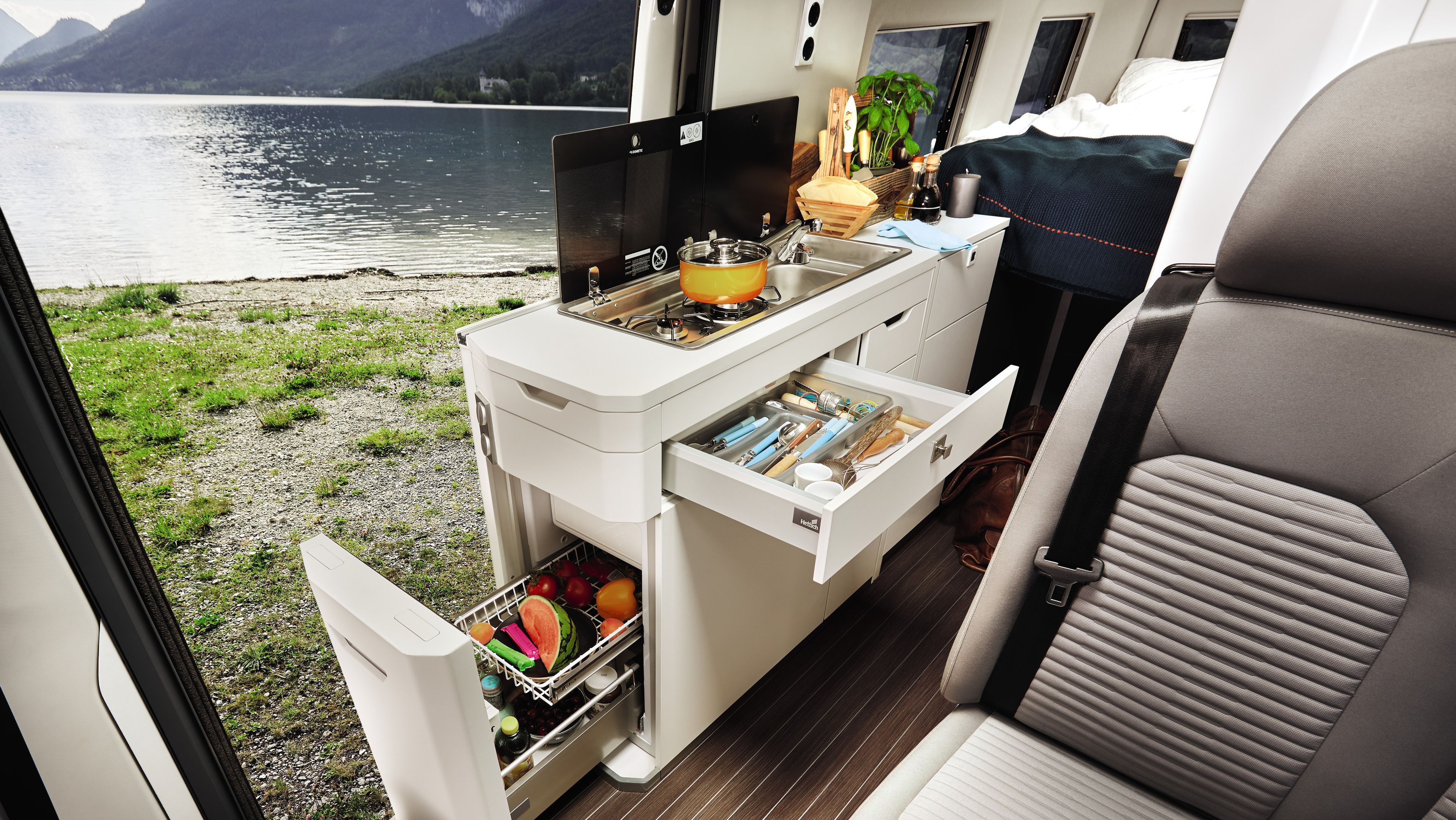 Die geräumige Küche im VW Grand California ist zu sehen. Die Laden sind geöffnet. 