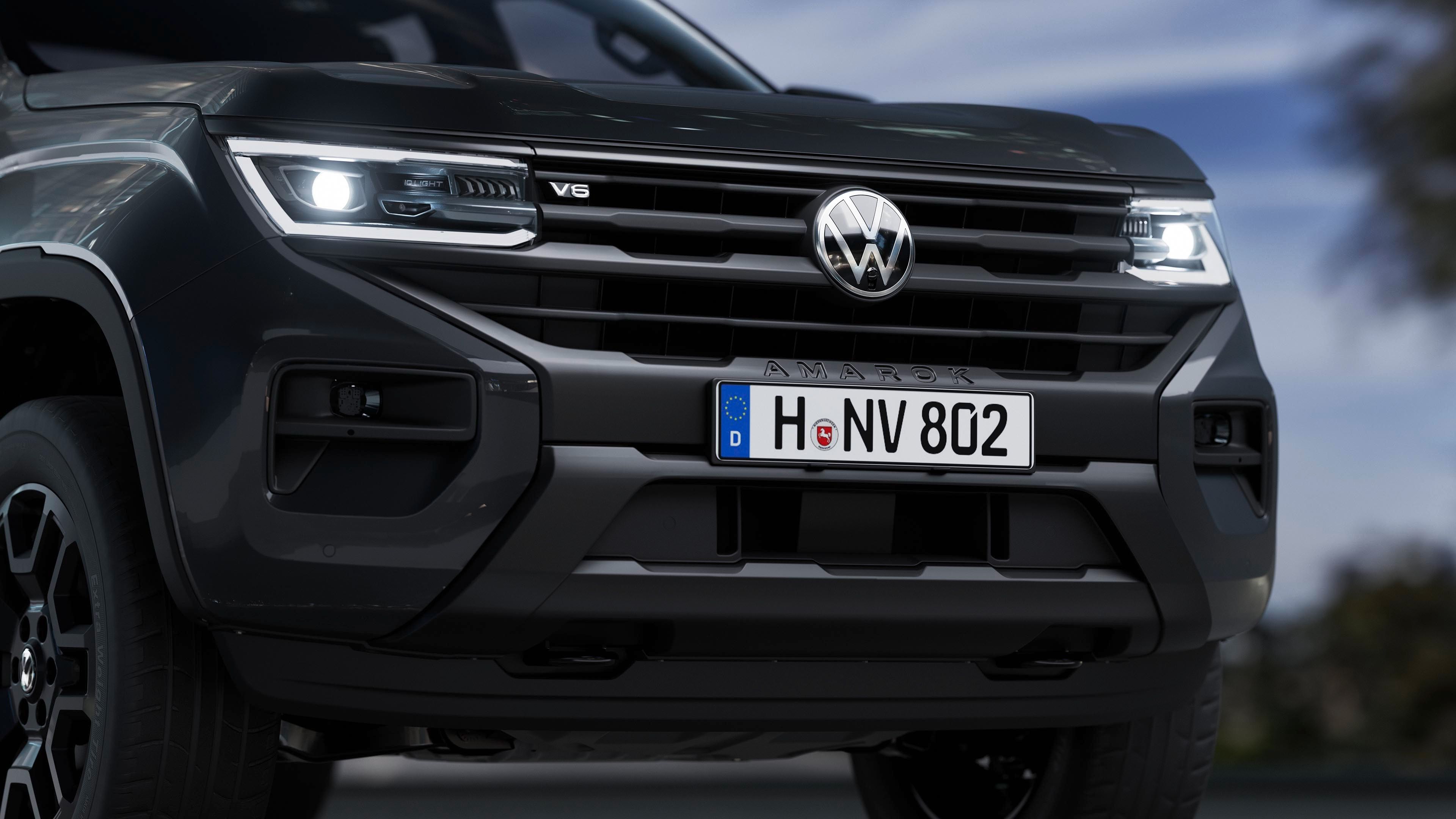 Bližnji posnetek sprednjega dela sivega Volkswagna Amaroka z avstrijskimi registrskimi tablicami. Vozilo ima sodoben dizajn in LED žaromete. Registrska tablica prikazuje črke "SE" in številke "264 RC".