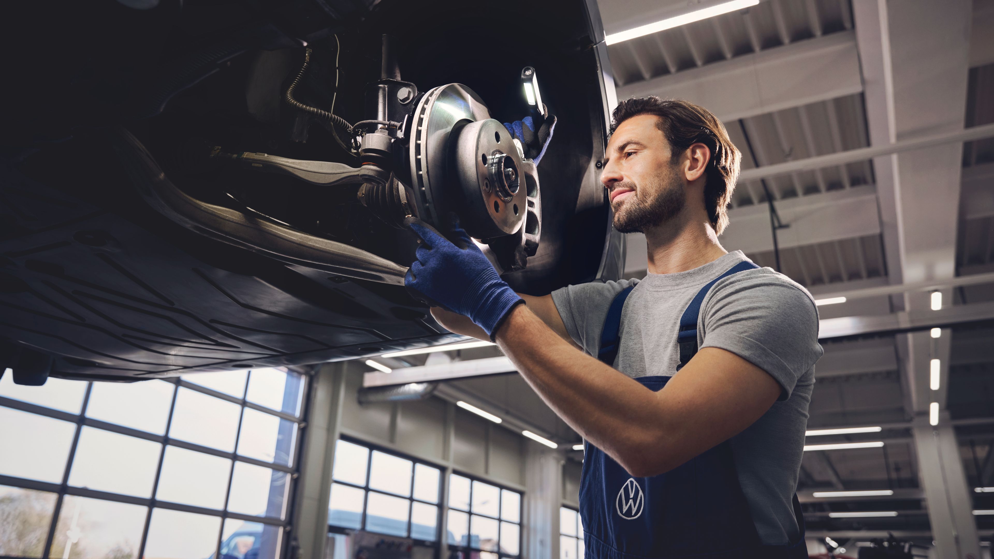 Servisni mehanik pregleduje zavore na vozilu Volkswagen Gospodarska vozila