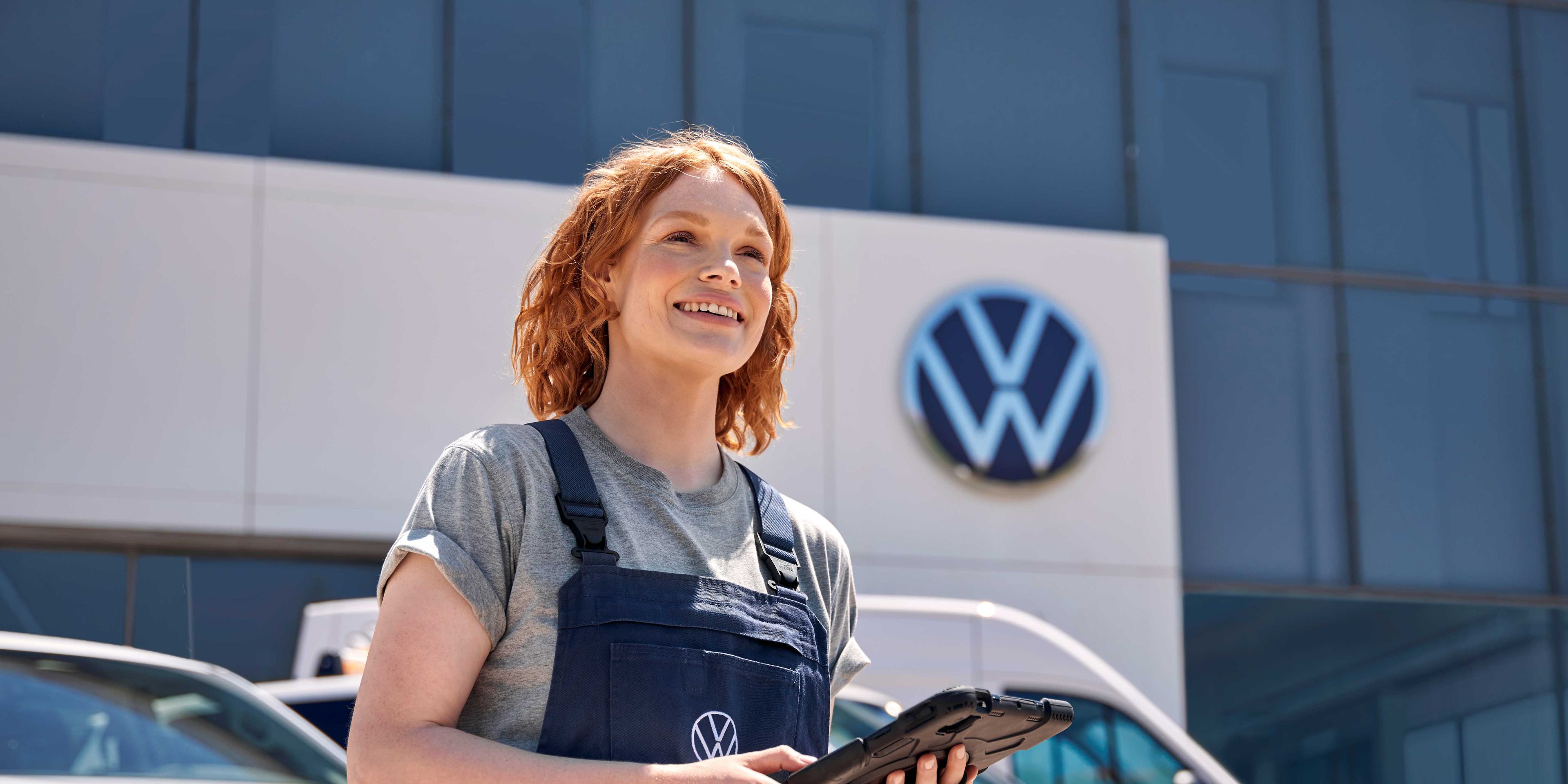 Servisni tehnik stoji pred Volkswagen prodajnim salonom.