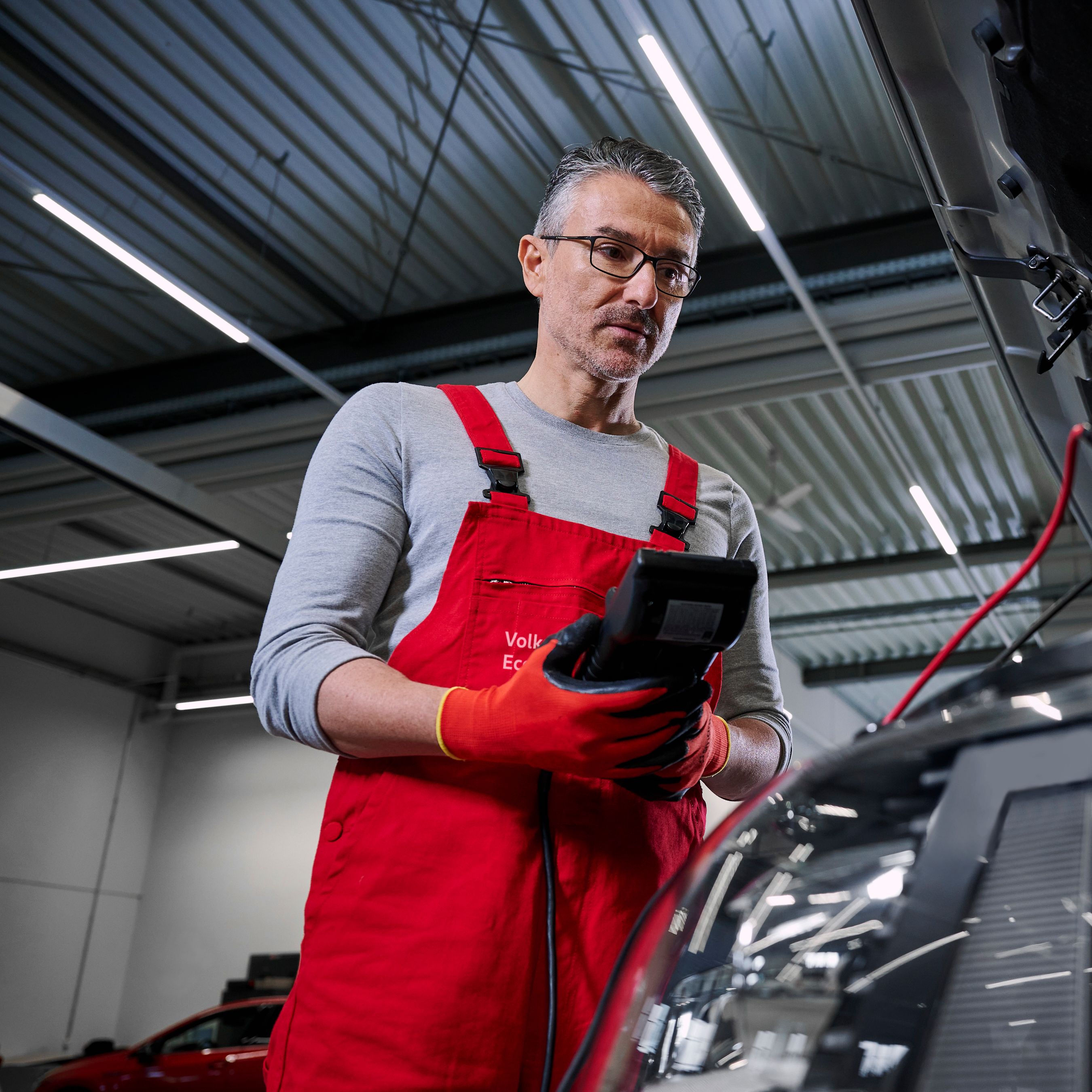 Volkswagnov mehanik preverja napetost baterije Volkswagna