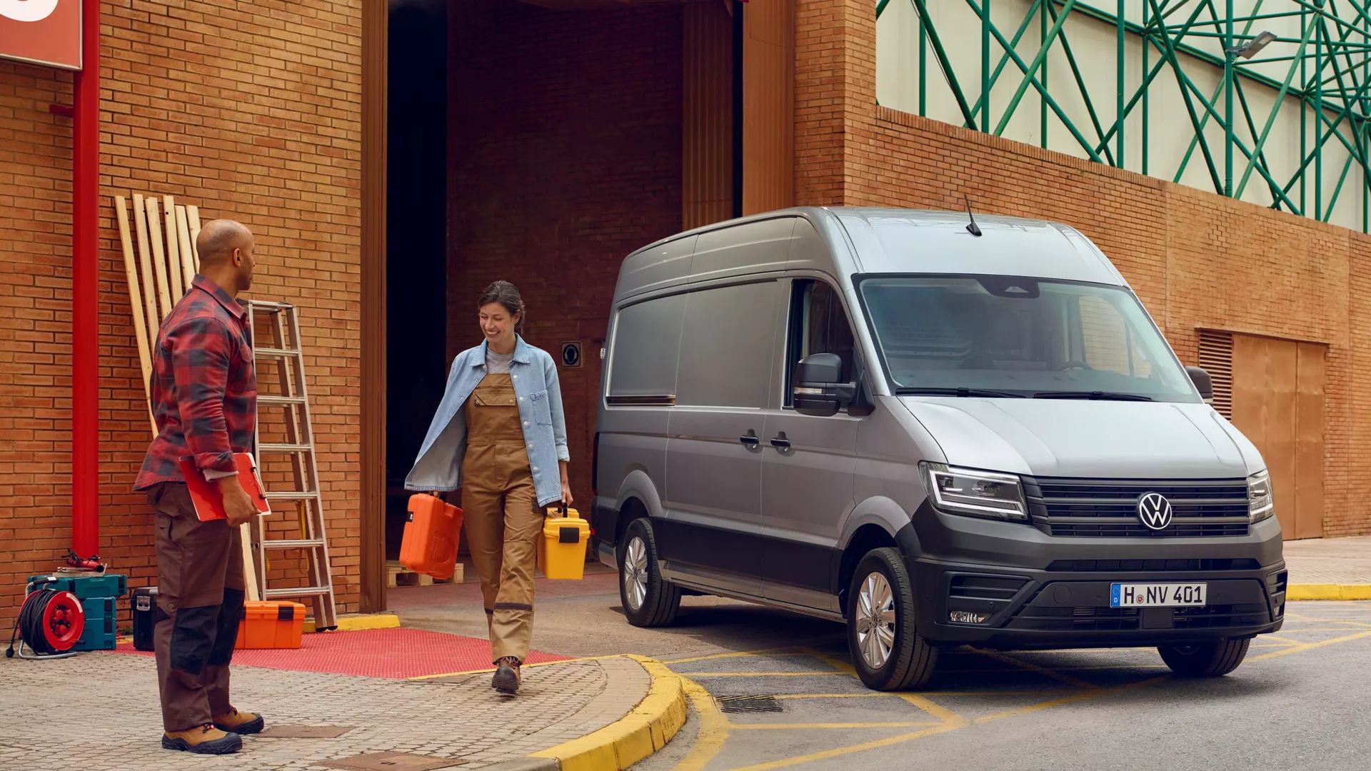 Zwei Handwerker neben einem silbernen VW Crafter