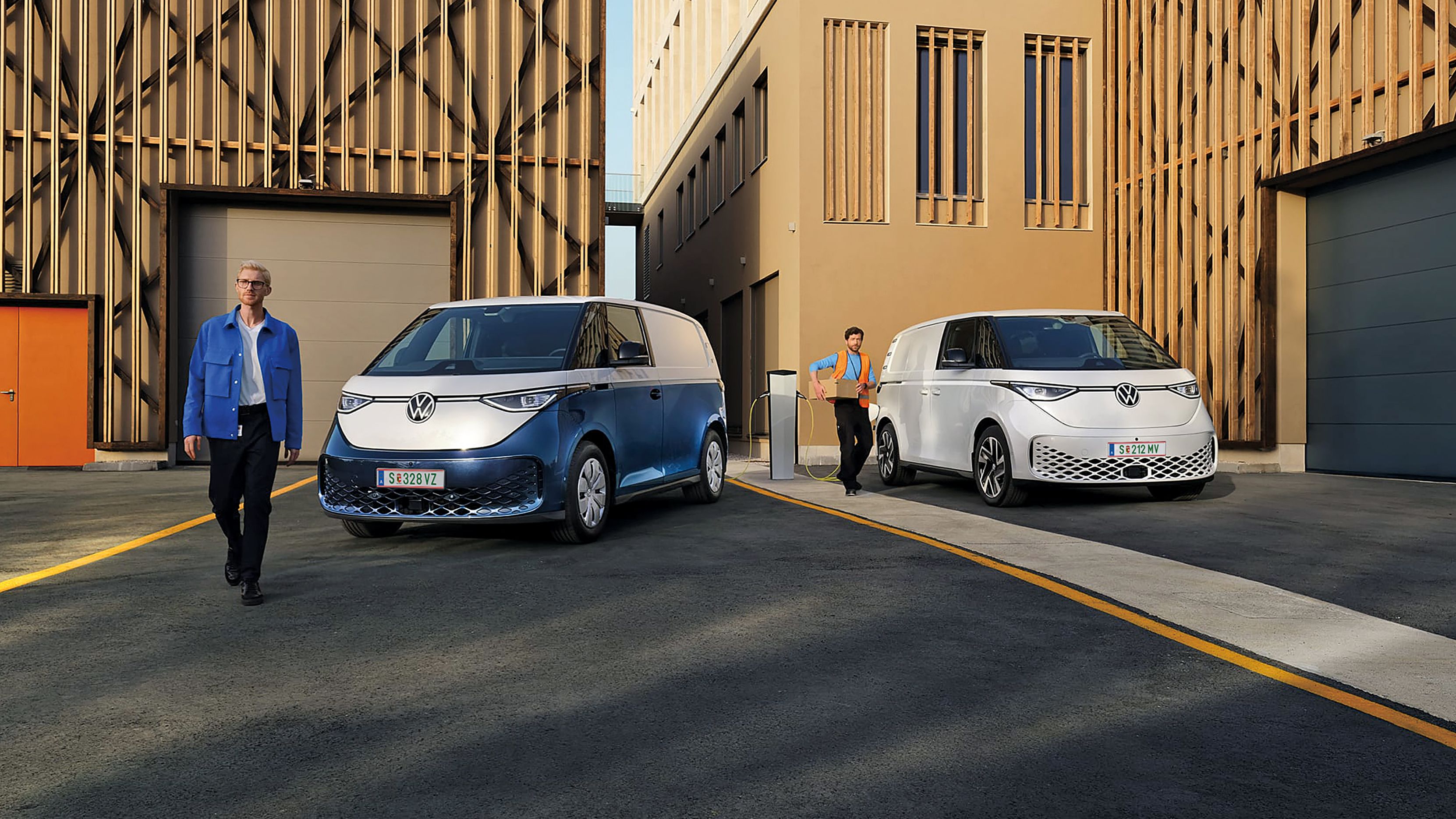 Heck des neuen VW T7 Multivan Style ist zu sehen und ein Mann und eine Frau spazieren vorbei