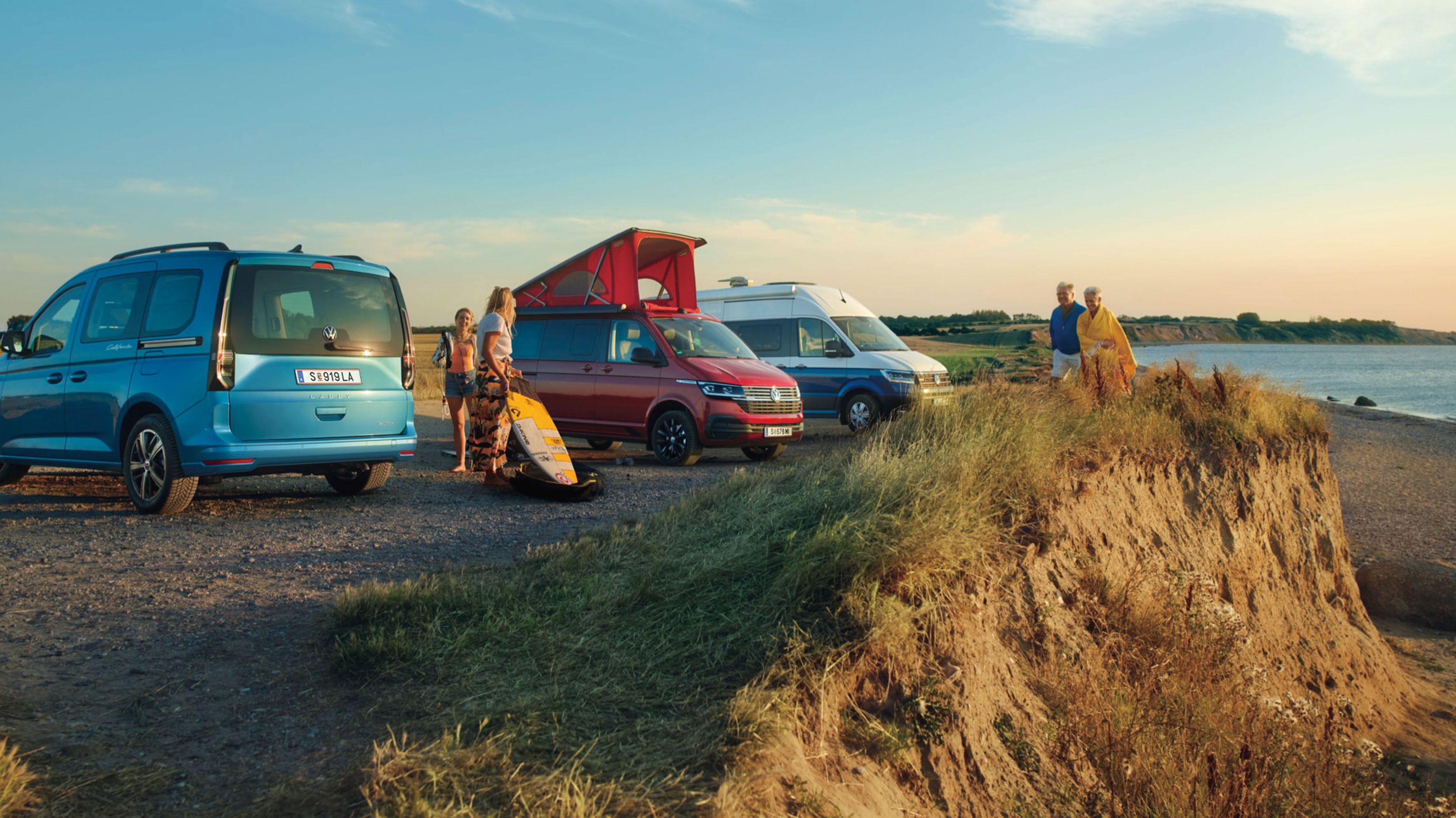 VW Caddy blau, Grand California und California 6.1 stehen nebeneinander am Strand
