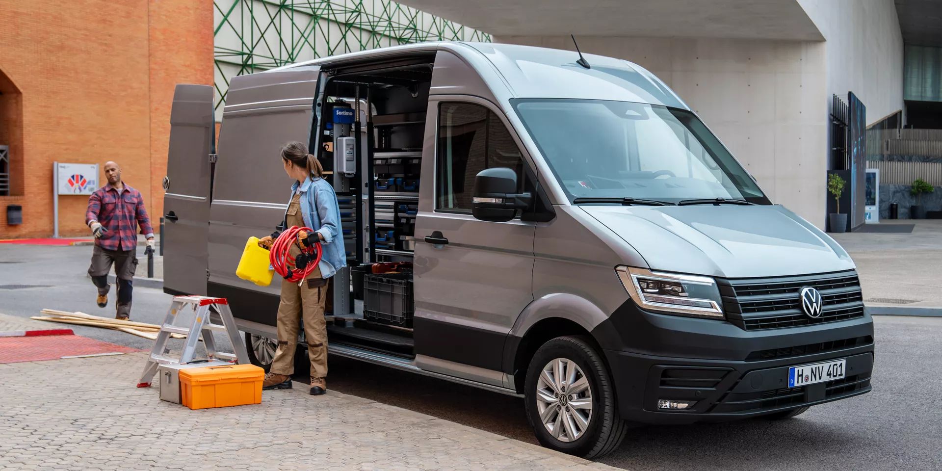VW Crafter mit geöffneten Türen, zwei Handwerker stehen um das Auto herum