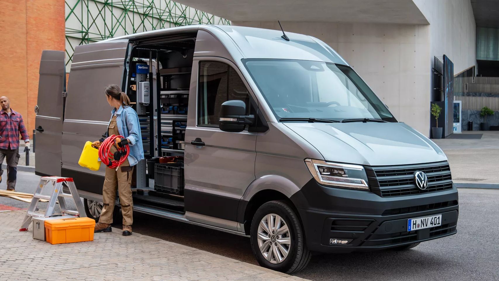 VW Crafter mit geöffneten Türen, zwei Handwerker stehen um das Auto herum