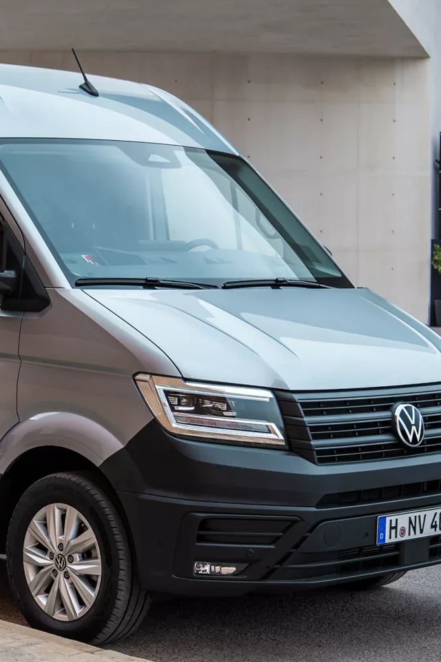 VW Crafter mit geöffneten Türen, zwei Handwerker stehen um das Auto herum