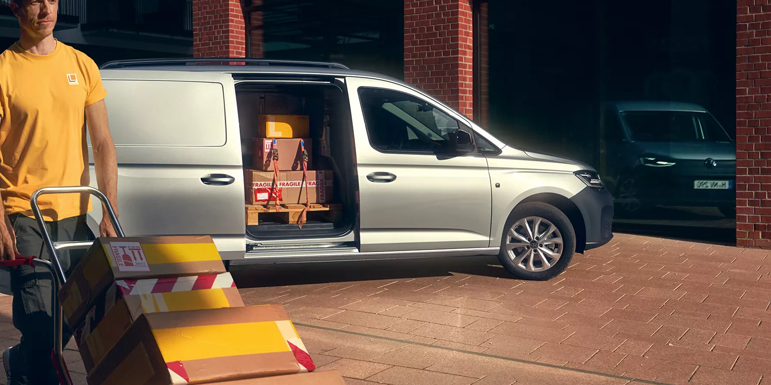 Mann entlädt einen silbernen Caddy Cargo
