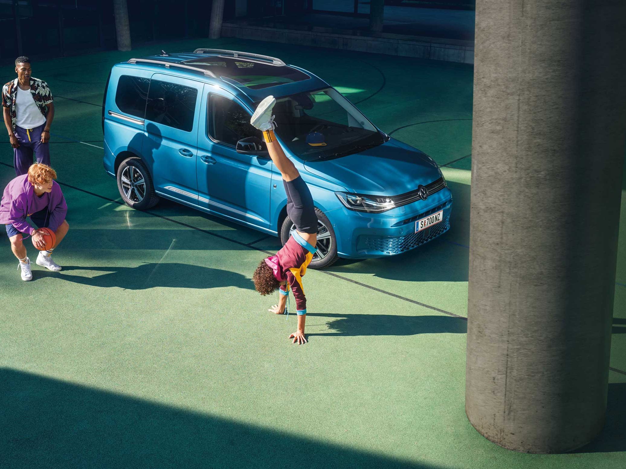 Kinder spielen vor einem VW Caddy