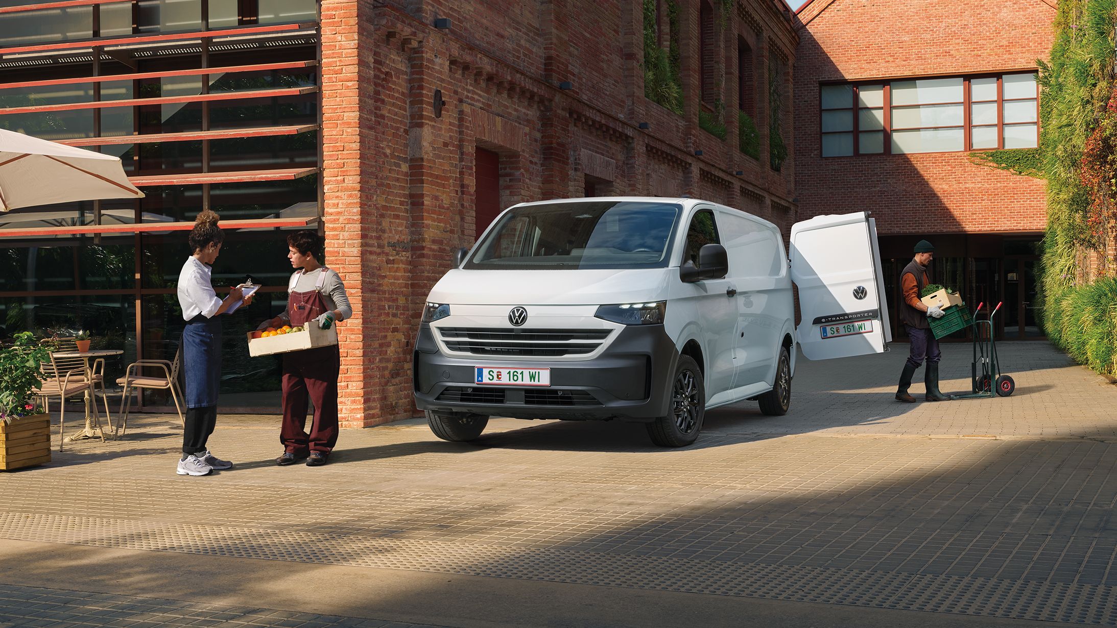VW Transporter Kastenwagen in Weiß steht vor Haus