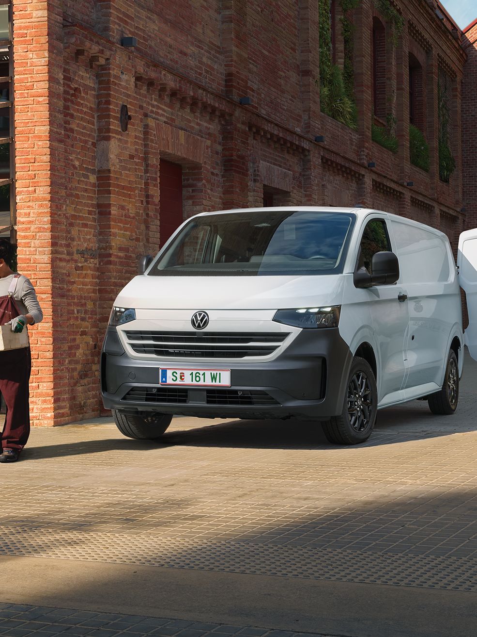 VW Transporter Kastenwagen in Weiß steht vor Haus