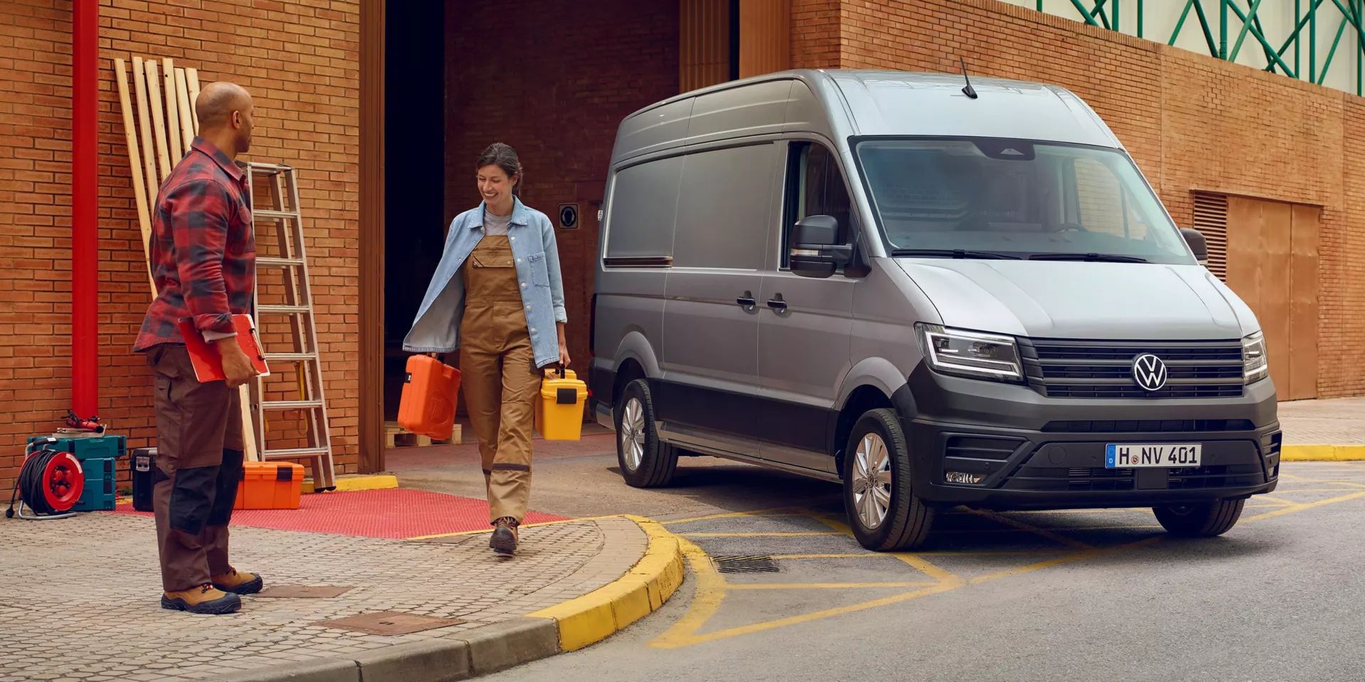 Zwei Handwerker neben einem silbernen VW Crafter