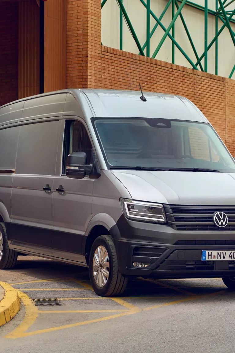Zwei Handwerker neben einem silbernen VW Crafter