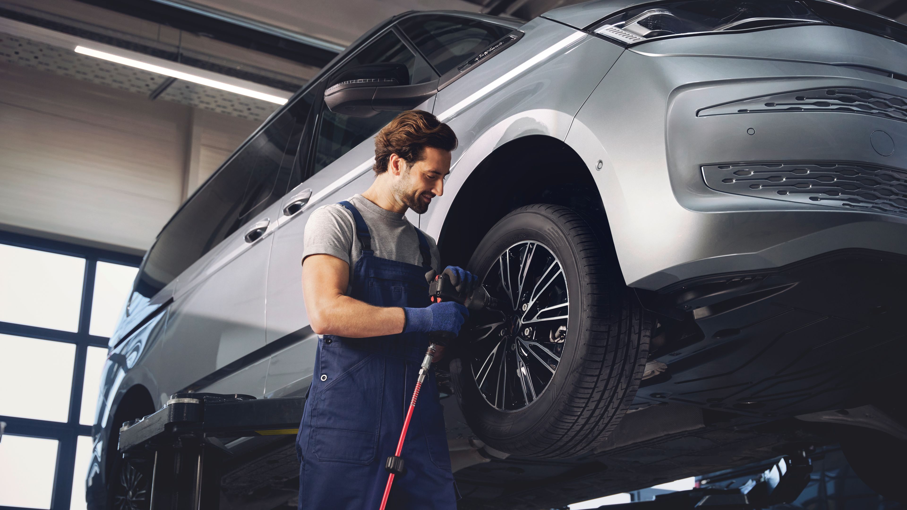 Servisni tehnik menja kolesa na VW Multivanu.