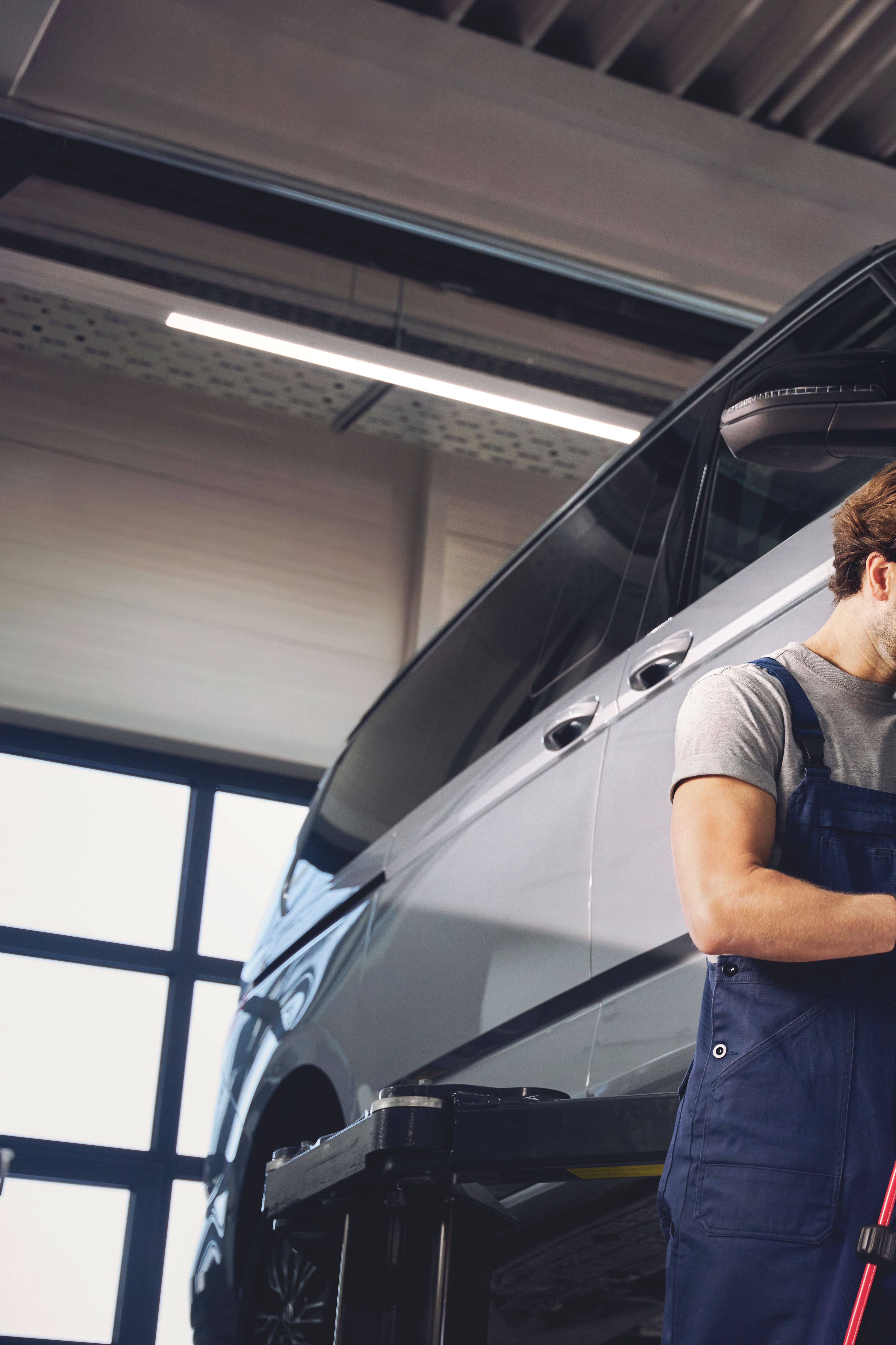 Servisni tehnik menja kolesa na VW Multivanu.