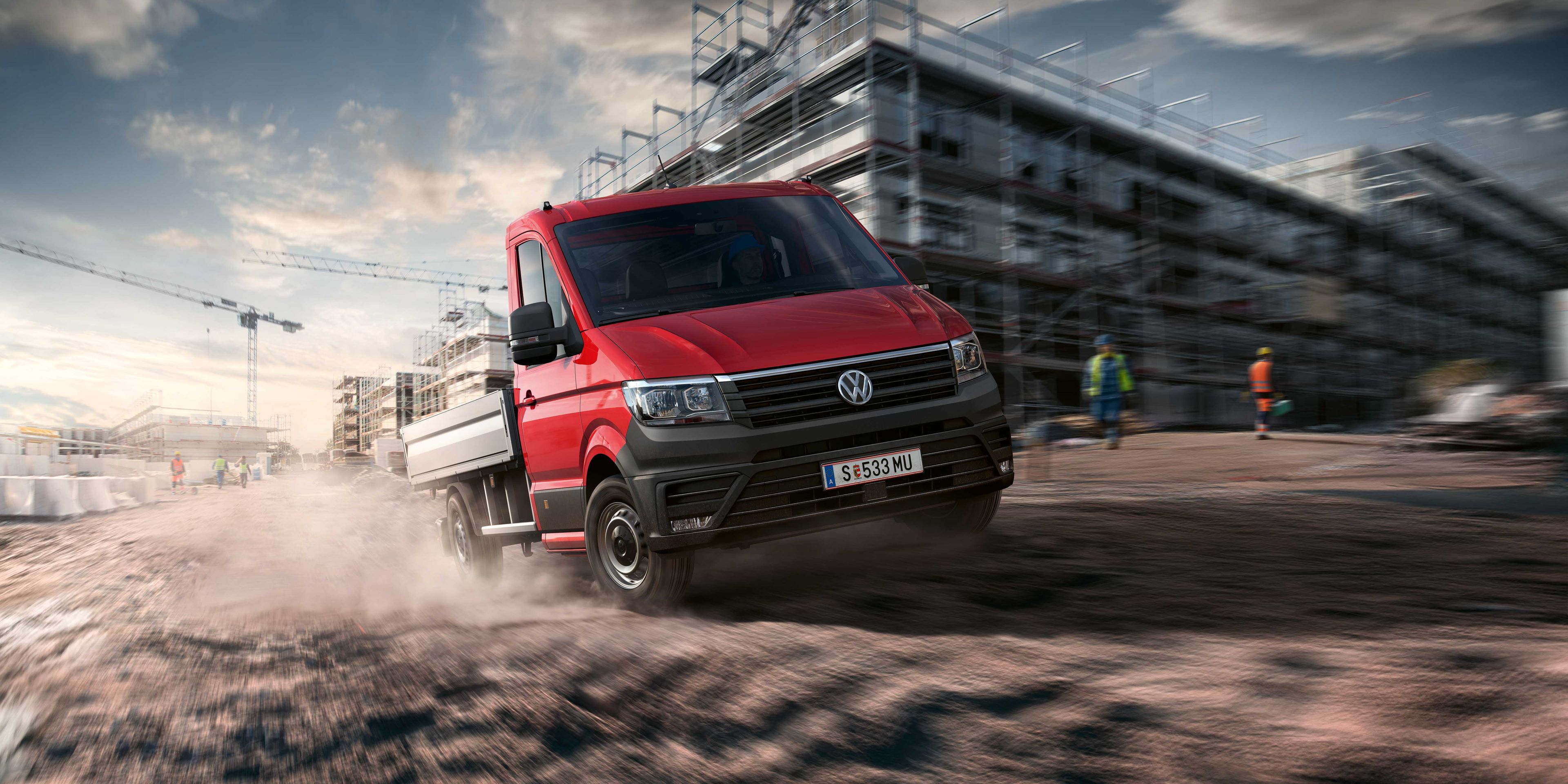 Ein VW Crafter Pritschenwagen in Fahrt auf einer Baustelle