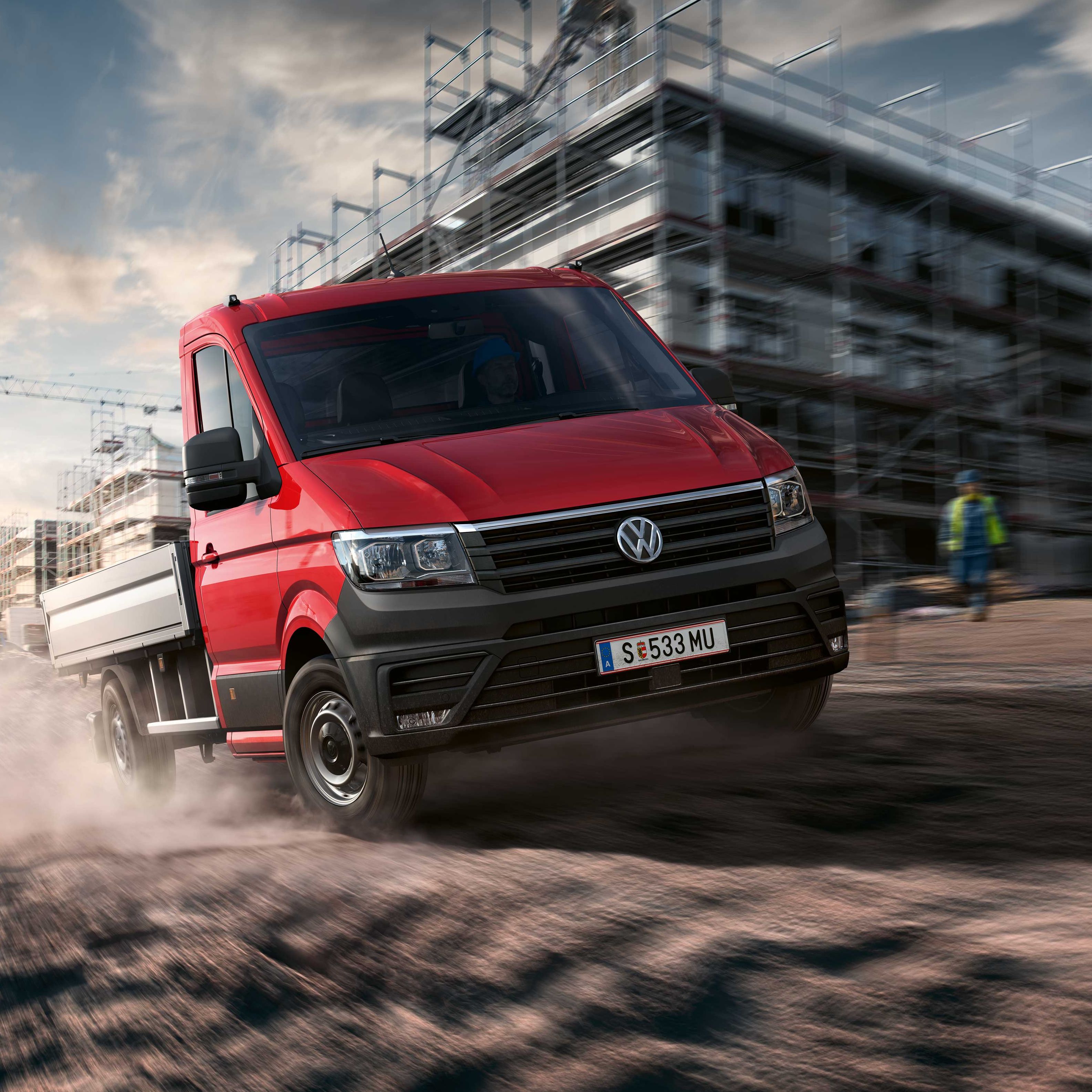 Ein VW Crafter Pritschenwagen in Fahrt auf einer Baustelle