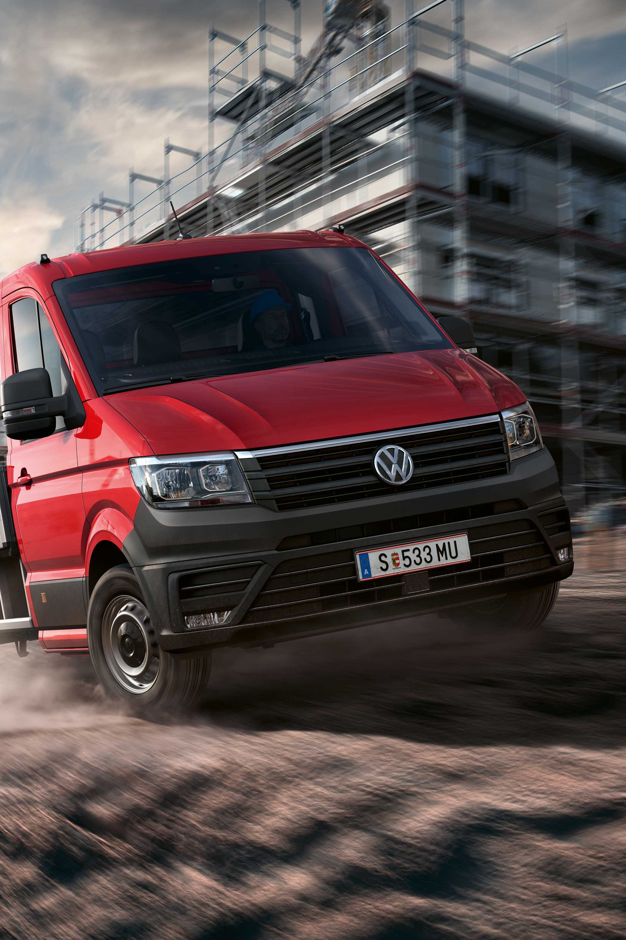 Ein VW Crafter Pritschenwagen in Fahrt auf einer Baustelle