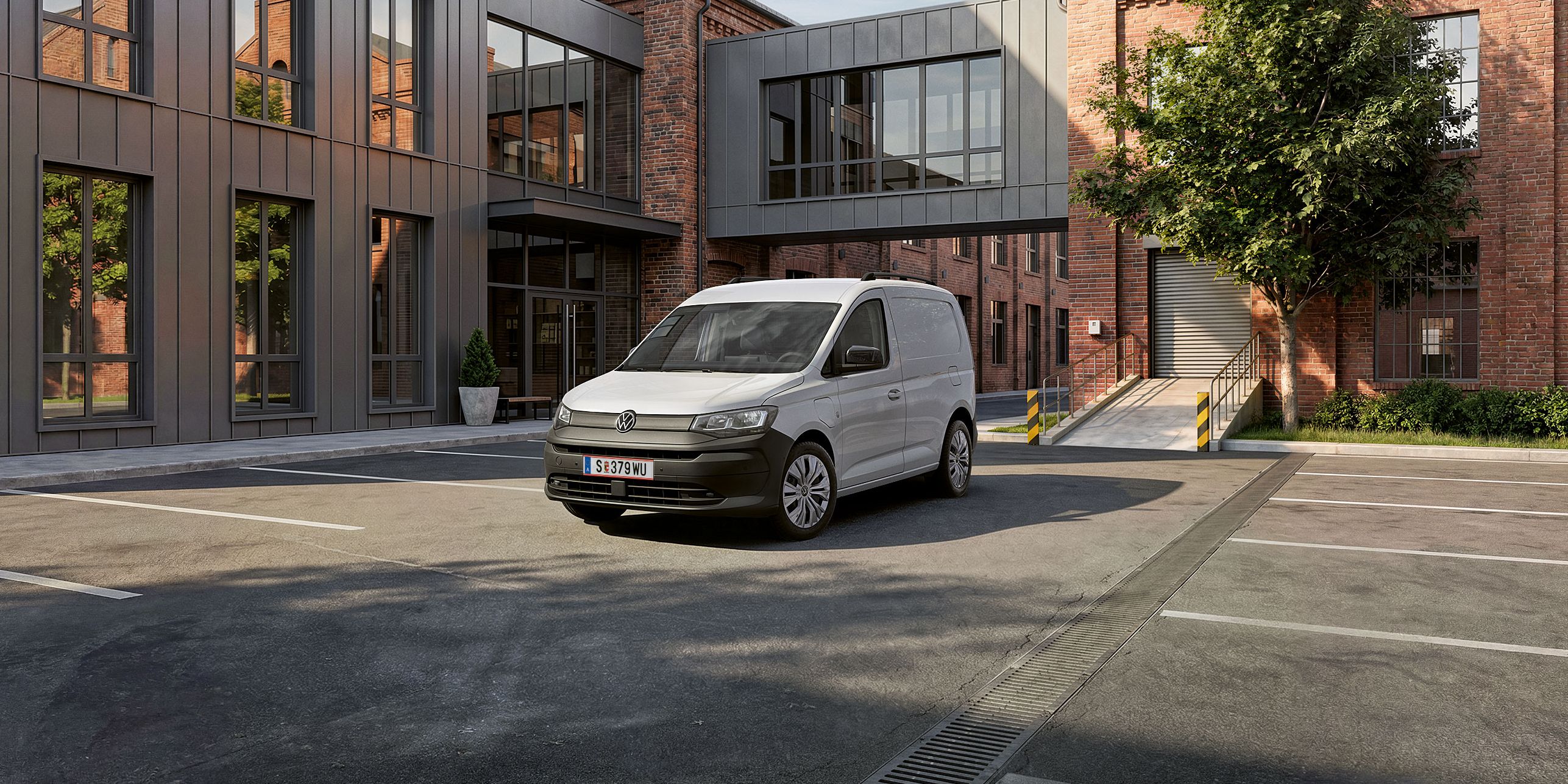 Der neue Caddy Cargo in Weiß steht vor Gebäude.