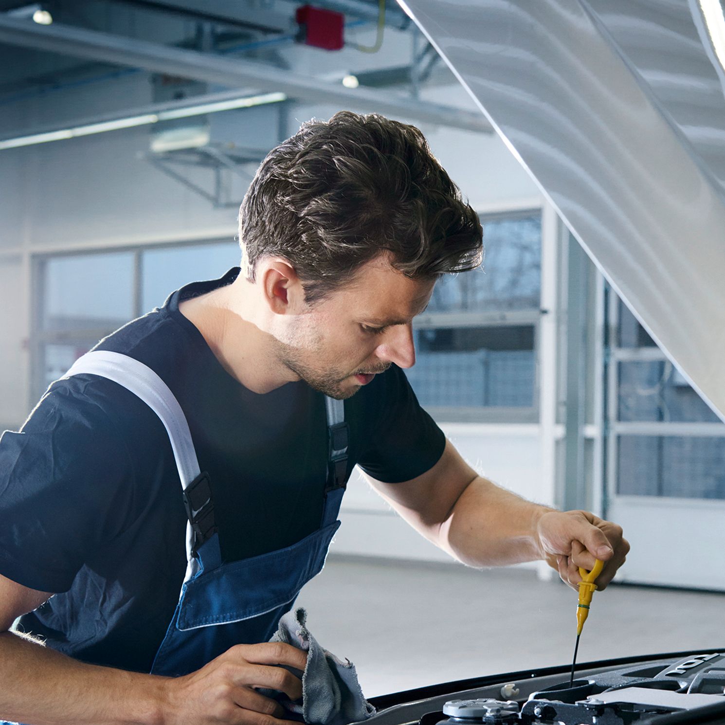 Ein Volkswagen Techniker beim Messen des Ölstandes