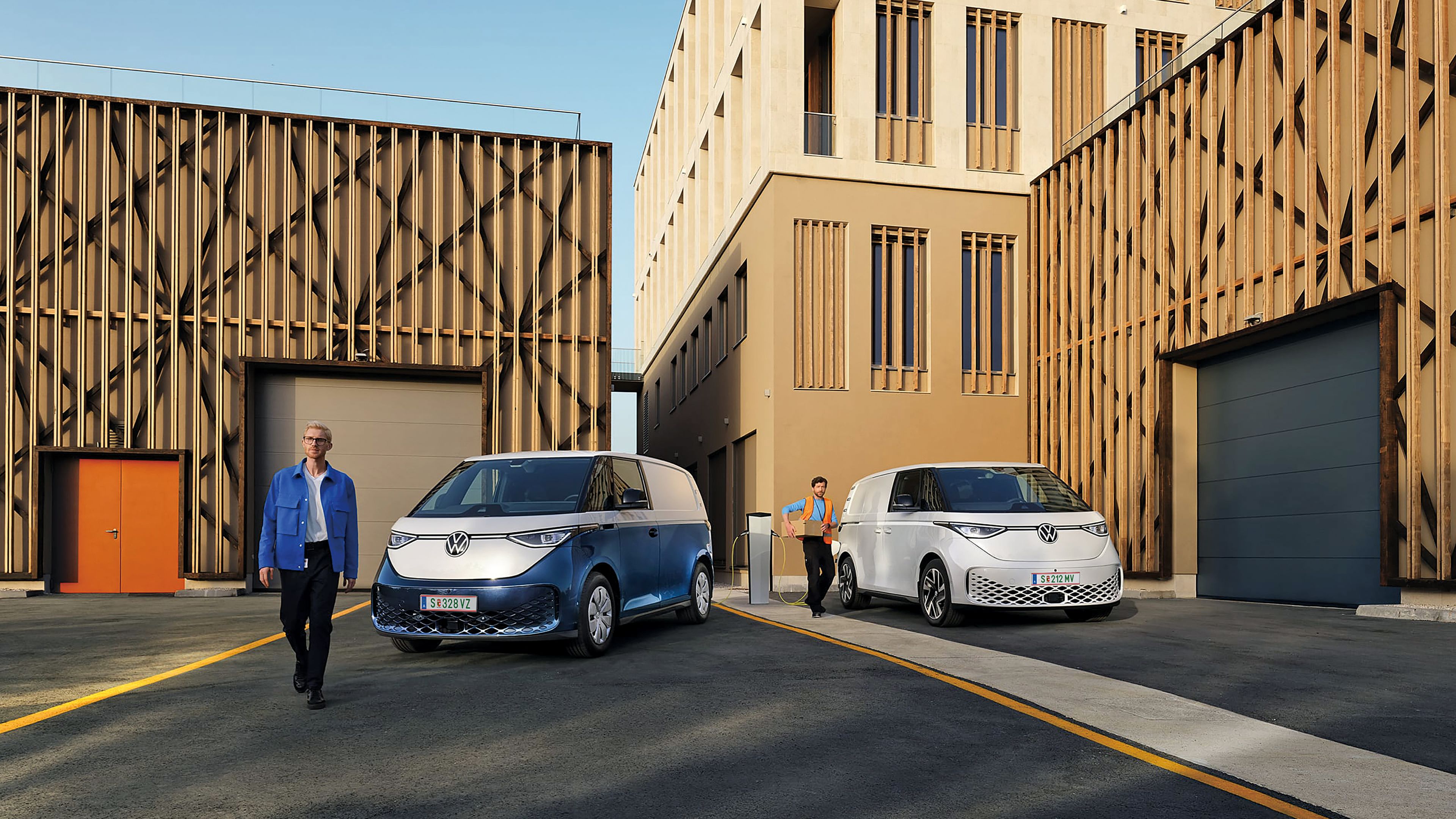 Heck des neuen VW T7 Multivan Style ist zu sehen und ein Mann und eine Frau spazieren vorbei