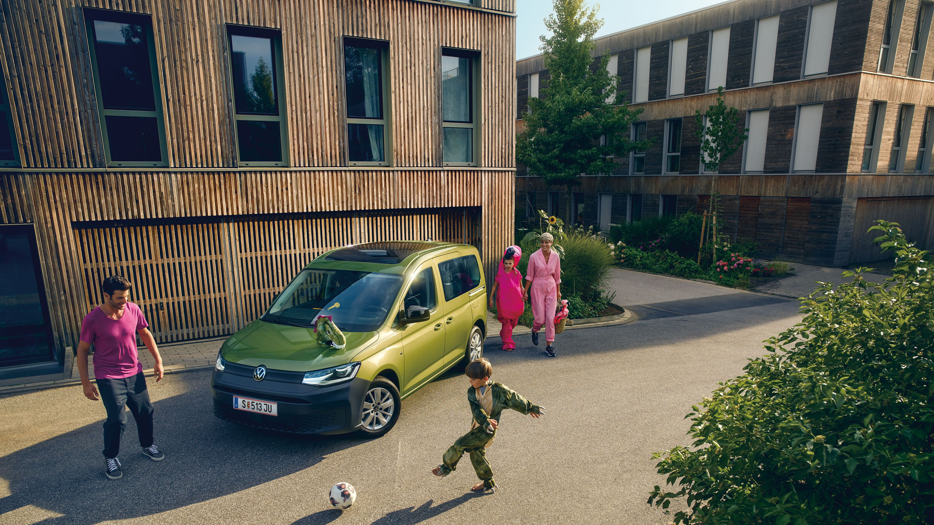 Kinder spielen vor einem Volkswagen Caddy