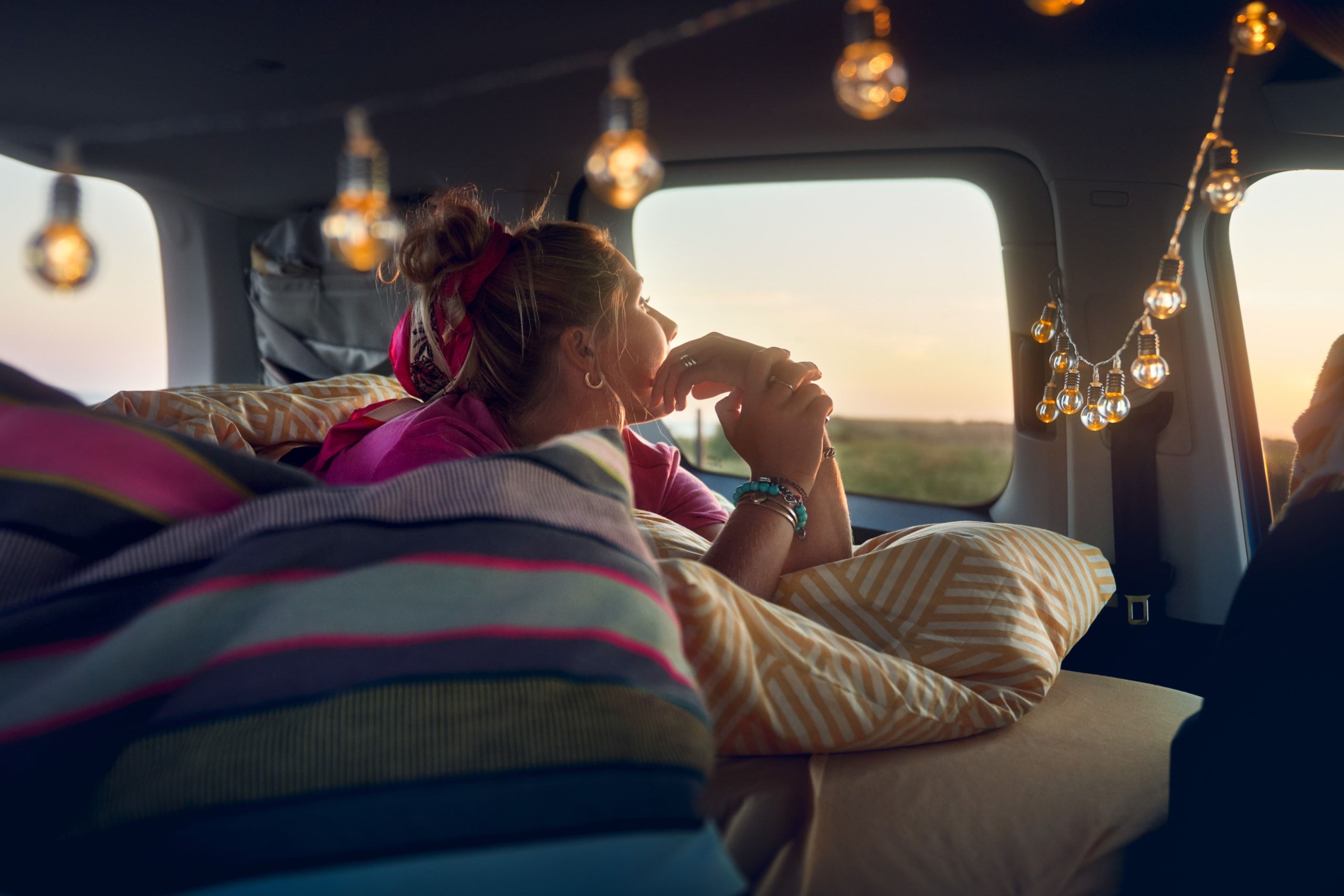 Eine Frau liegt am ausklappbaren Bett des Caddy California